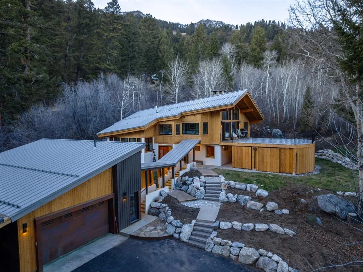 Mountain home exterior with standing seam metal roof and stone landscaping