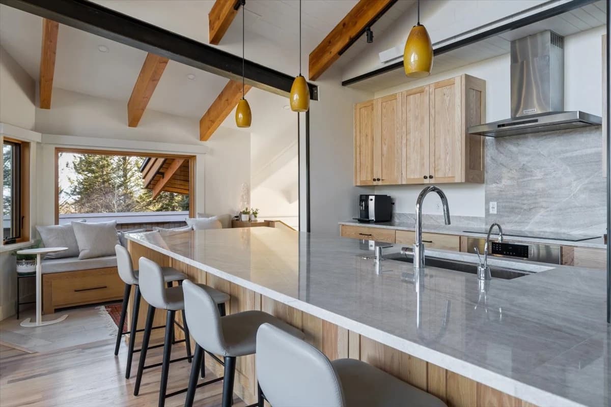 Modern kitchen with waterfall marble island and pendant lighting