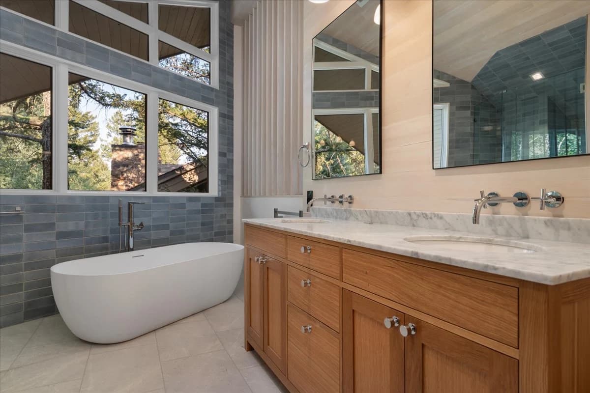 Primary bathroom with freestanding tub and tiled accent wall