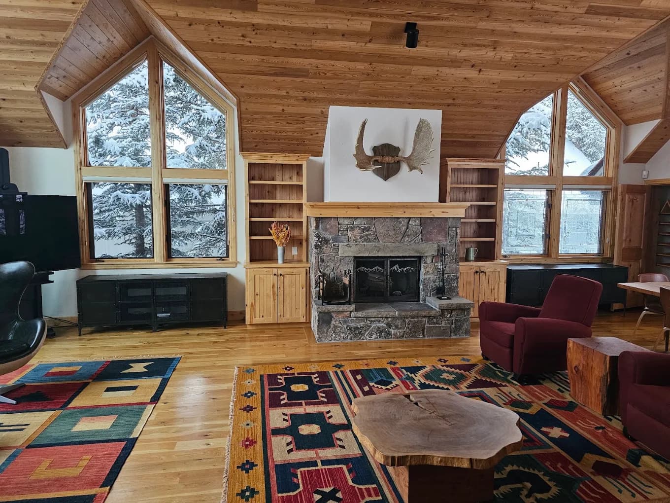 Rustic living room with stone fireplace and mounted antlers