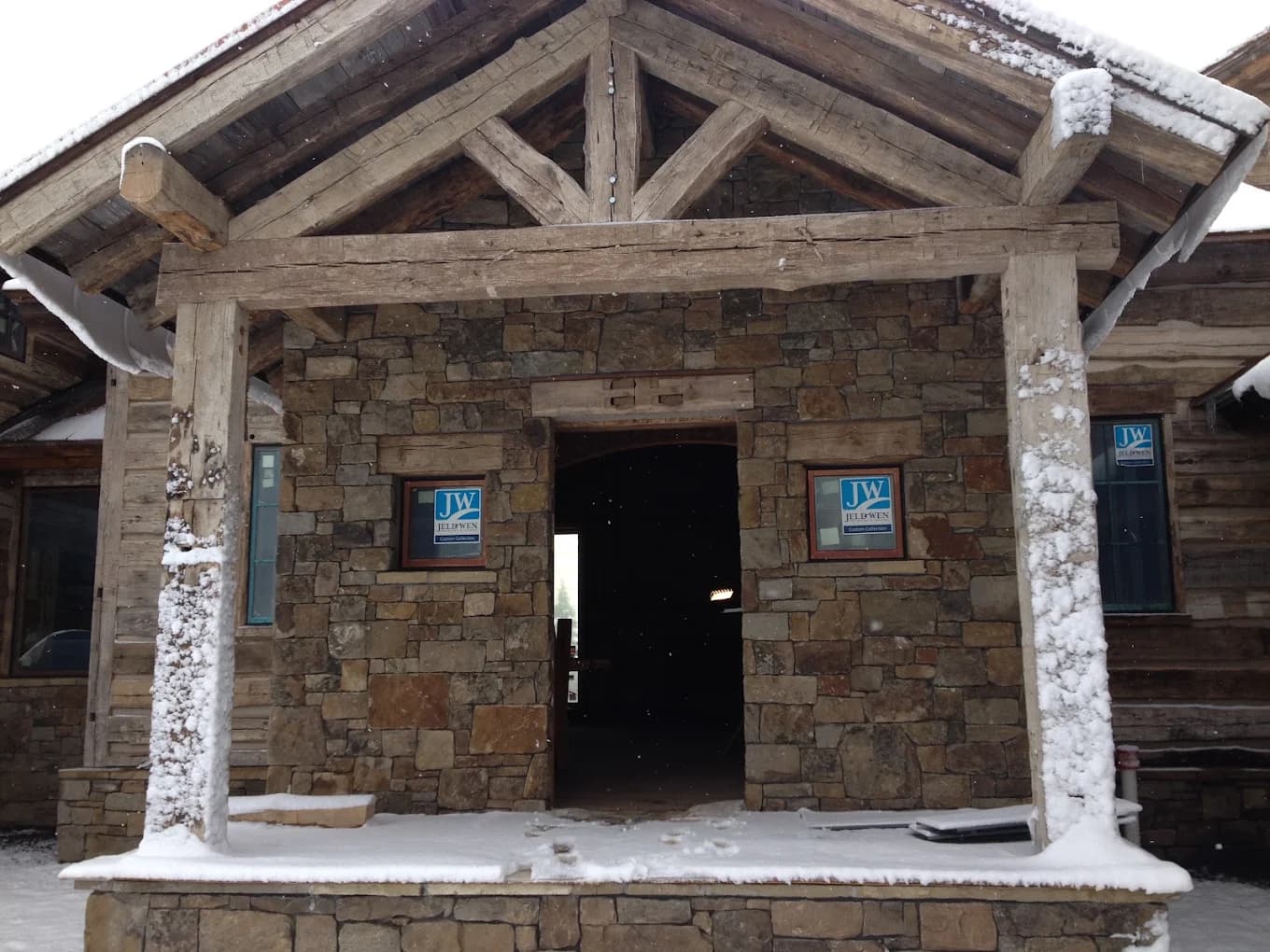 Stone entry porch under construction with snow on the ground