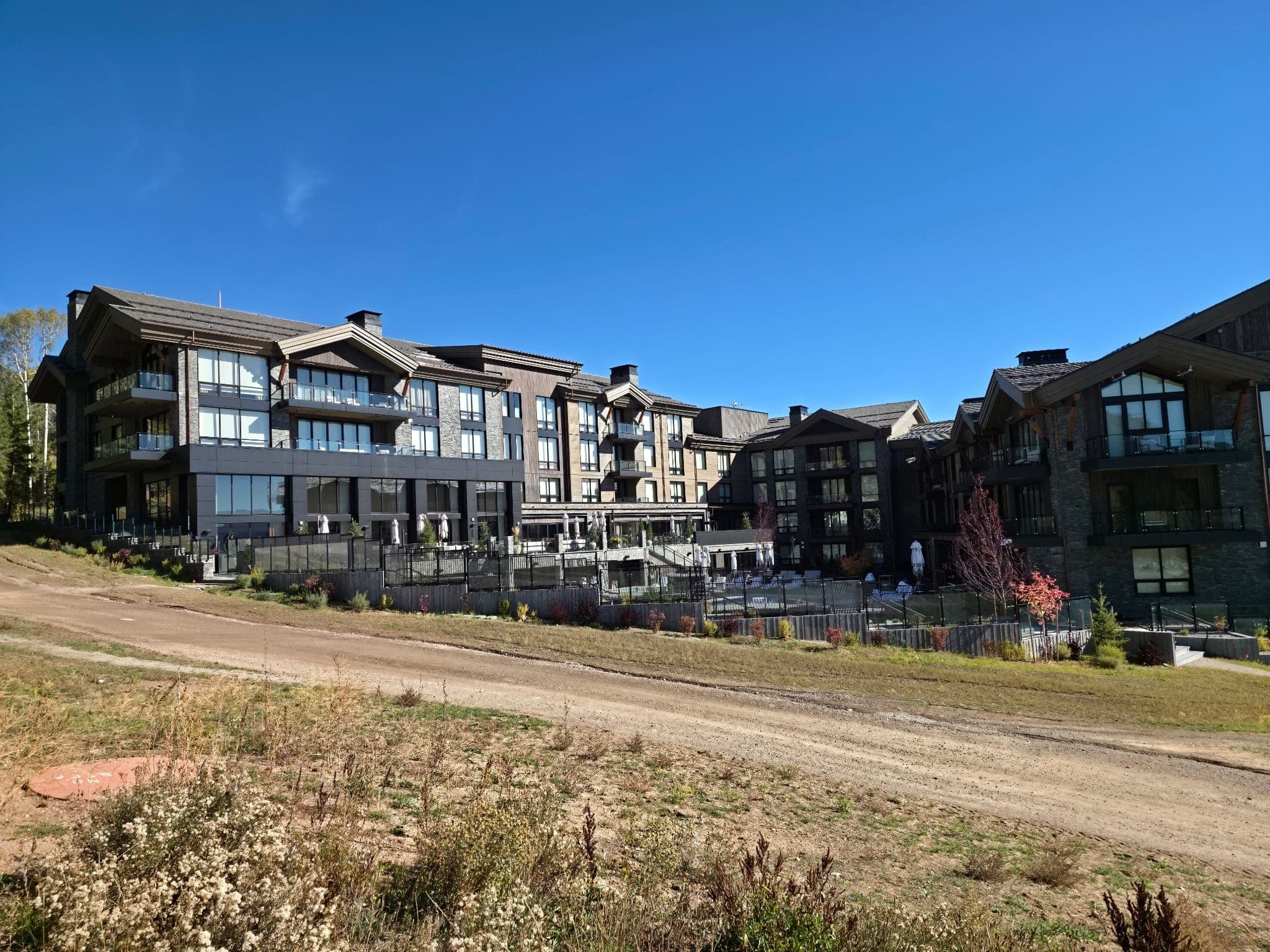 Hoback Club's stone and timber courtyard elevation with terraced landscaping in Teton Village, Wyoming